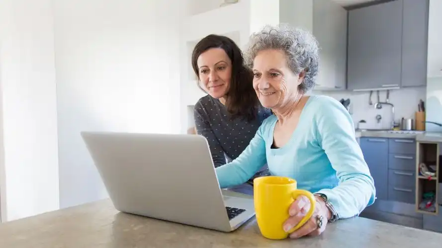 Two women looking at a laptop screen.